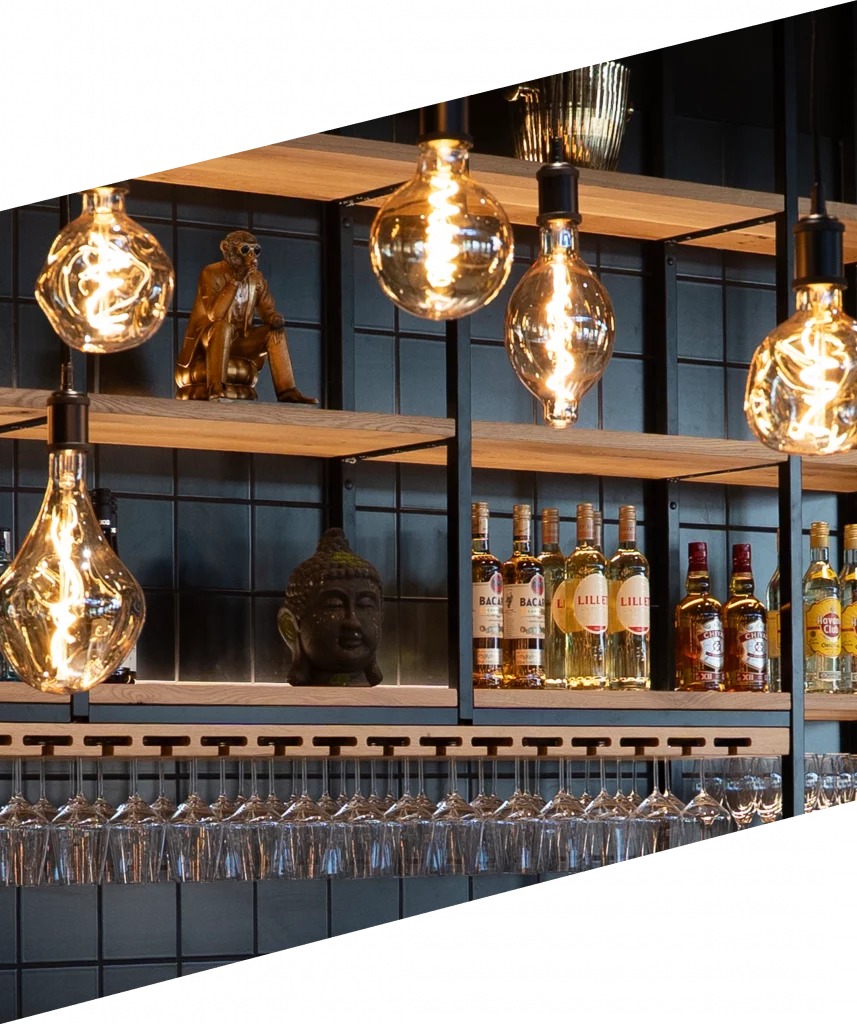 Bar im werk3 Veitshöchheim mit beleuchteten Flaschen, warmen Lichtern und dekorativen Elementen.